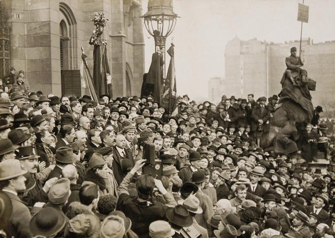 Potem ko je antanta podprla ozemeljske zahteve Češkoslovaške, Romunije in Kraljevine SHS do Madžarske, je marca 1919 odstopila liberalna vlada. Oblast so prevzeli socialisti in komunisti. Predsednik nove vlade je bil socialist Sandor Garbai (mož z brki na sredi množice, ob Beli Kunu), dejansko glavni v vladi pa je bil vodja komunistov Kun, in sicer zaradi svojih dobrih zvez s Kremljem. | Foto: Thomas Hilmes/Wikimedia Commons