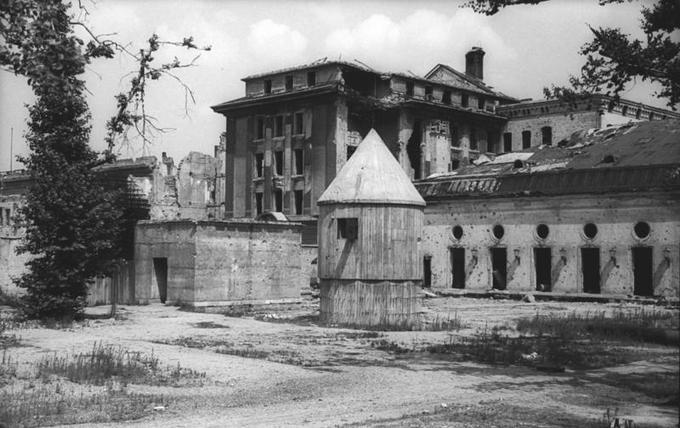 Zadnji vhod v bunker oziroma tako imenovani Führerbunker, kjer je svoje zadnje dni preživljal Adolf Hitler. Ta fotografija je nastala leta 1947 malo pred tem, ko so poslopja Sovjeti zravnali s tlemi, podzemni kompleks bunkerja, kjer so bili bivalni prostori, pa je razmeroma ohranjen ostal do konca 80. let prejšnjega stoletja, ko so ga končno uničili.  | Foto: Thomas Hilmes/Wikimedia Commons