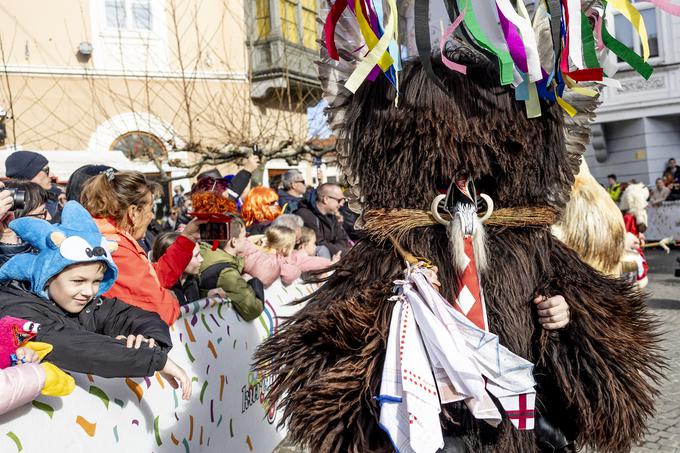 Mimoidoči, predvsem dekleta, kurentom na ježevko navežejo robce. Kurent, ki ima največ robcev, naj bi bil najlepši.  | Foto: Ana Kovač