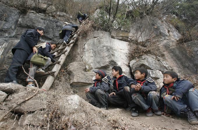 Xu Liangfan, ravnatelj osnovne šole na Kitajskem, spremlja študente v šolo. Provinca Guizhou, Kitajska. | Foto: Reuters