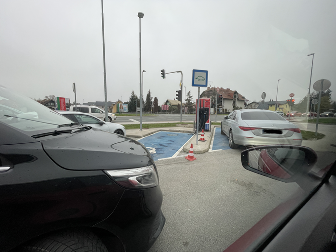 Vsakdanji pogled lastnikov električnih avtomobilov. Pred levim polnilnim mestom je parkiran kombi, ki ovira dostop. Na desni strani je voznik mercedesa svojo limuzino parkiral pa na dobro označeno mesto, namenjeno polnjenju električnih avtomobilov. | Foto: Gašper Pirman