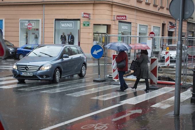 Gradbišče na križišču Pražakove in Miklošičeve ulice v Ljubljani je dobilo žičnate panele, skozi katere lahko pešci zdaj vidijo na cesto, preden stopijo na prehod.  | Foto: Bojan Puhek